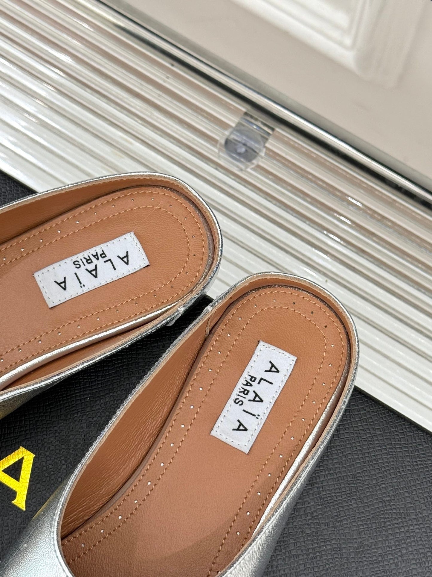 ALAIA FLAT MULE IN SILVER LAMBSKIN